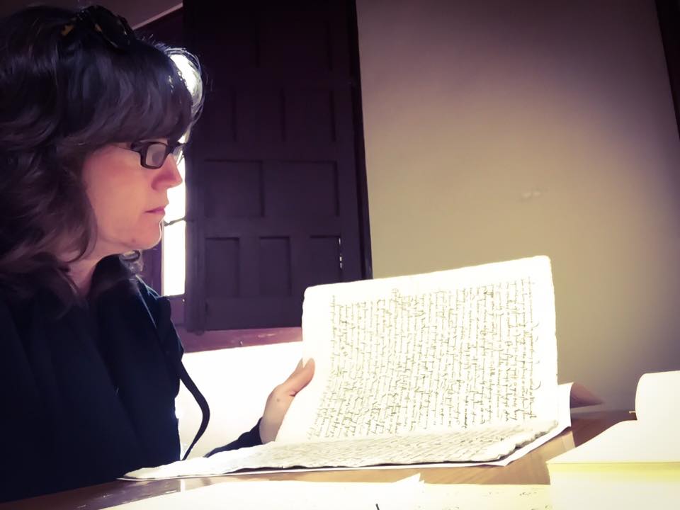 Ana Afzali examining a letter from King Ferdinand to Diego Deza.